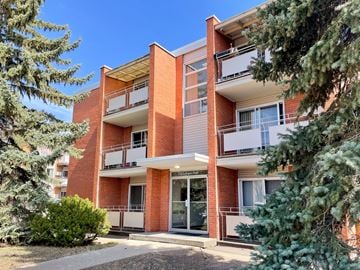 Regina apartment for rent - A red brick apartment building with a balcony on the second floor.