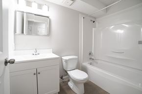Regina apartment for rent - A white bathroom with a toilet, sink, and bathtub.