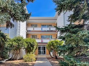 Regina apartment for rent - A building with a balcony and a glass door is surrounded by trees.