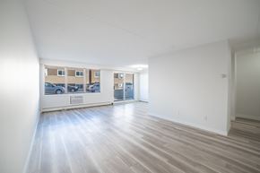 Regina apartment for rent - A spacious room with wooden flooring and white walls.