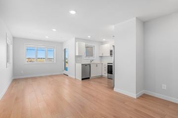 Saskatoon apartment for rent - A kitchen with white cabinets and a wooden floor.