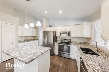 Mesa house for rent - a white kitchen with marble counter tops and stainless steel appliances