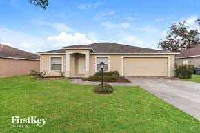 Lakeland house for rent - a beige house with a driveway and a lawn