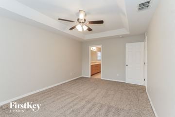 Lakeland house for rent - a spacious living room with a ceiling fan and a carpet