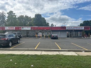 Camp Springs apartment for rent - A laundromat and barbershop are located in a parking lot.