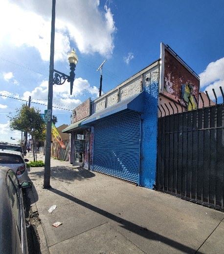 Los Angeles apartment for rent - A blue building with a closed shutter and a black gate.