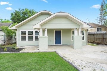 Houston house for rent - a white house with a blue door and a lawn