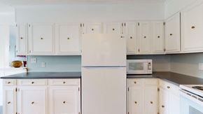 Emerald Isle house for rent - a white kitchen with white cabinets and a white refrigerator