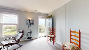 Emerald Isle house for rent - a living room with rocking chairs and a door to a balcony