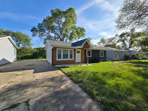 Gary house for rent - the front of a small house with a driveway and lawn