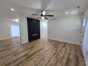 Gary house for rent - a living room with a ceiling fan and a door to a bedroom