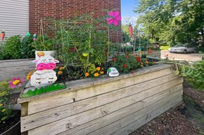 Foley apartment for rent - A wooden planter box with a decorative cow statue and a variety of plants.