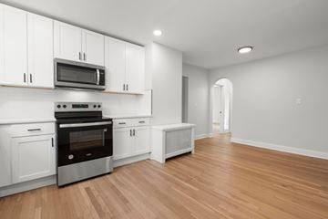 Hamden apartment for rent - A kitchen with white cabinets and a wooden floor.