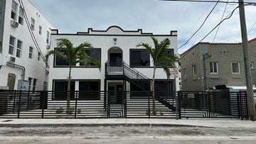 Miami apartment for rent - A white building with a black staircase in front.