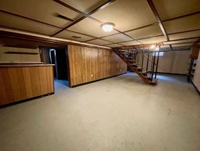 New Albany house for rent - A room with wooden walls and a staircase.