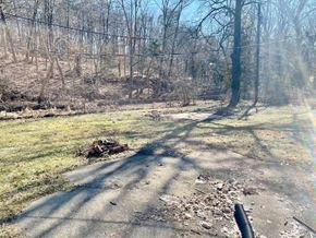 New Albany house for rent - A road with a black pipe on the right side and trees in the background.