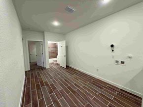 San Antonio apartment for rent - a spacious living room with white walls and wood flooring