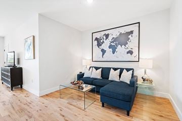 Newark apartment for rent - A living room with a blue couch and a world map on the wall.
