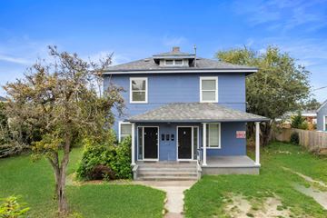 Tacoma apartment for rent - the front of a blue house with a lawn and a tree