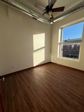 Grinnell apartment for rent - A room with a ceiling fan and a window.