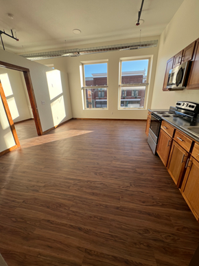 Grinnell apartment for rent - A room with wooden floors and a window overlooking a cityscape.