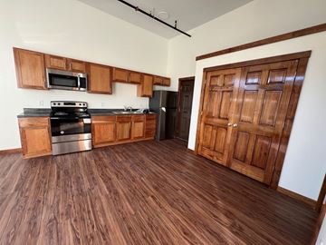 Grinnell apartment for rent - A kitchen with wooden floors and a wooden door.