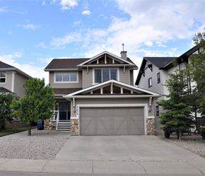 Airdrie house for rent - A two-story house with a garage and a stone pillar in front.