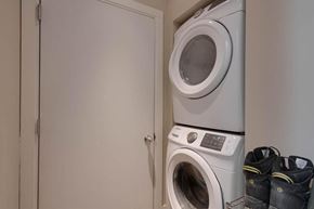 Calgary apartment for rent - A pair of shoes are placed on a shelf next to a washing machine.