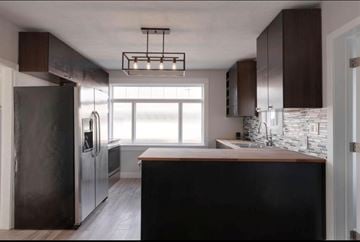 Calgary apartment for rent - A modern kitchen with dark wood cabinets and a large island.
