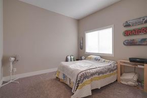 Calgary apartment for rent - A bedroom with a bed, a window, and a skateboard on the wall.