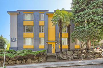 Seattle apartment for rent - a blue and yellow building with a palm tree in front of it