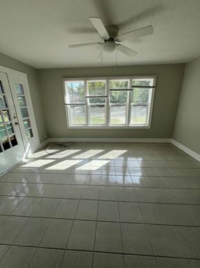 Indianapolis apartment for rent - an empty living room with a ceiling fan and windows