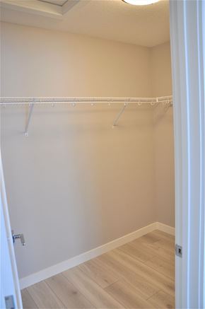 Chestemere house for rent - A white closet with a wooden floor and a white door.