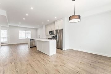 Calgary house for rent - an open kitchen and living room with a island and a stainless steel refrigerator