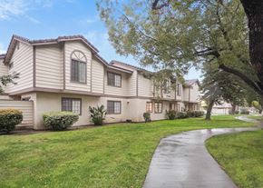 Redlands apartment for rent - A residential building with a well-maintained lawn and a paved walkway.