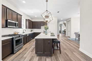 Richmond house for rent - A modern kitchen with dark wood cabinets and a white island.