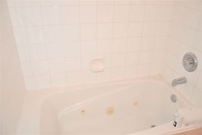 Calgary house for rent - A white bathtub with a shower head and faucet.