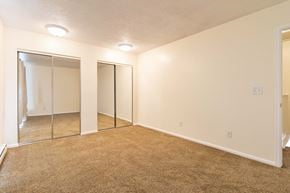 Lakewood house for rent - an empty bedroom with mirrored closet doors and carpeting