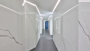 Los Angeles apartment for rent - a long white hallway with white marble walls and a blue door