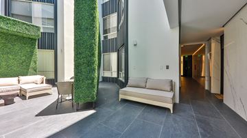 Los Angeles apartment for rent - a living area with a couch and chairs and a green wall