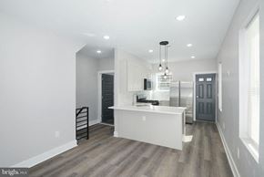 Philadelphia apartment for rent - an open kitchen and dining room with white walls and wood floors