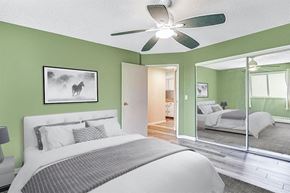 Calgary house for rent - A bedroom with a large bed and a ceiling fan.