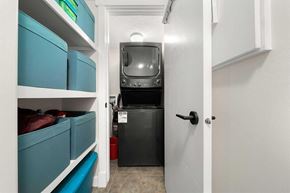 Calgary house for rent - A small kitchen with a black fridge and a white door.
