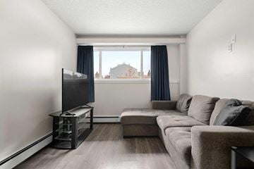 Calgary house for rent - A living room with a grey couch and a television.
