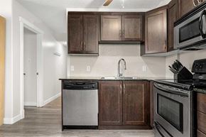 Calgary house for rent - A kitchen with dark wood cabinets and stainless steel appliances.