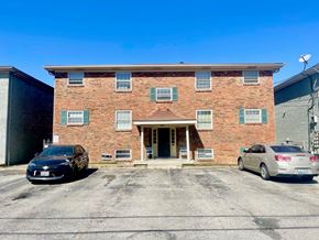 Louisville apartment for rent - an old brick building with two cars parked in front of it
