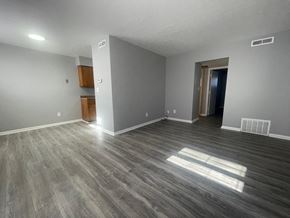 Louisville apartment for rent - an empty living room with wood flooring and grey walls