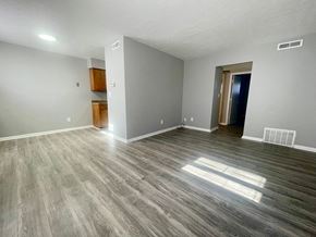 Louisville apartment for rent - an empty living room with wood flooring and grey walls