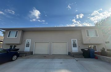 Kearney apartment for rent - a beige house with two garage doors and a driveway