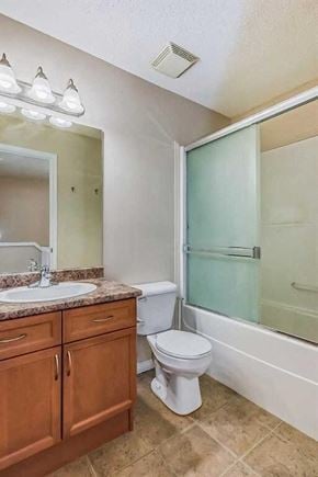Calgary house for rent - A bathroom with a toilet, sink, and shower.